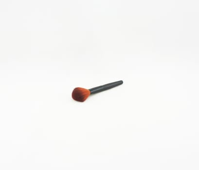 Blush brush with black handle placed on a white background.                               