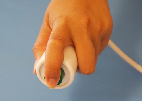 Human finger pushing button of nurse call in patient room.                                