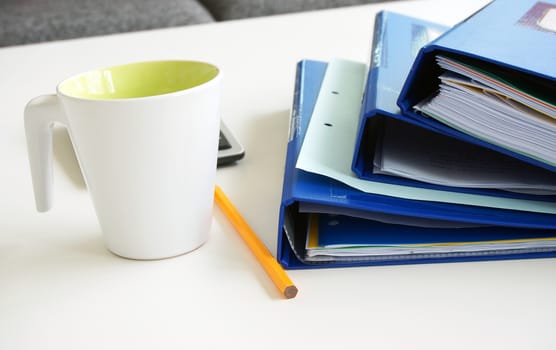 Working papers arrange on a dark blue folders, Placed on a table with a glass of water, pencil, calculator.                           