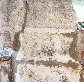 There is a crack in a concrete wall with cement paint at crack area.                               