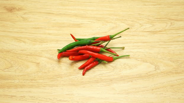 Both green and red chili paste together on the light brown table.                              