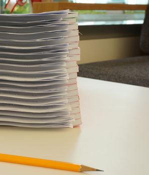 Many documents lay stacked in the workplace, waiting to be analyzed and reported.                              