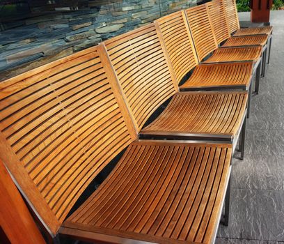 Several wooden chairs set in a park. For people to sit and relax, a place to meet.                               