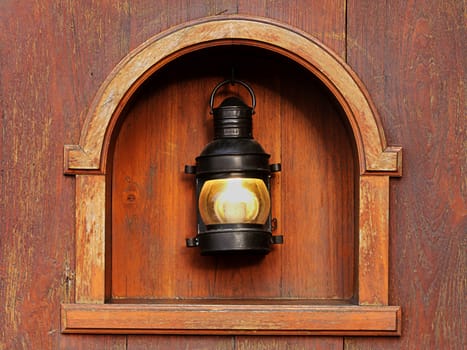 Old lamp on the wooden wall