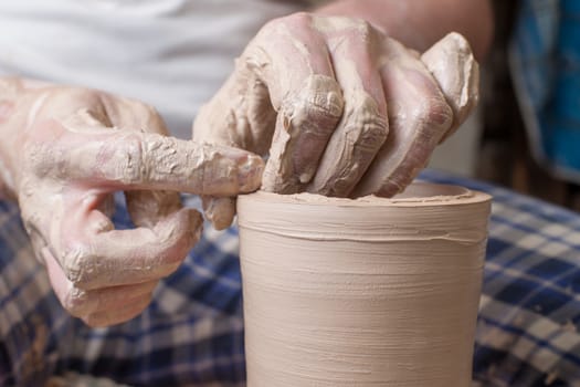 Hands of a potter, creating an earthen jar on the circle