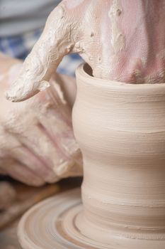 Hands of a potter, creating an earthen jar on the circle