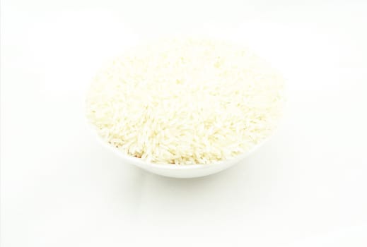 Uncooked rice, put in bowl. Placed on a white background.                               