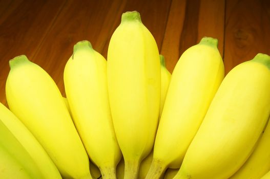 Ripe banana, have large size, gold colour, delicious, and beneficial to the body. Placed on a wooden table.                                 