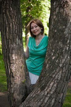 middle-aged woman walks in the Park in the summer of the tree