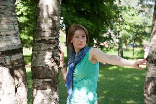 beautiful woman in birch summer in the Park for a walk