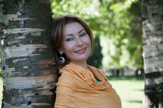 beautiful woman in birch summer in the Park for a walk