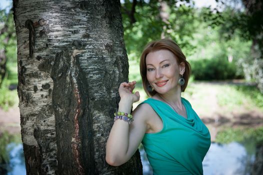 beautiful woman in birch summer in the Park for a walk