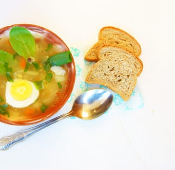 Plate of hot soup and bread on table