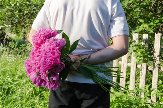 close up of man back with peony flower in hand