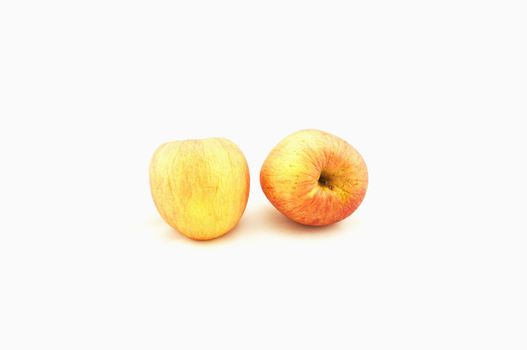 Two apples,the skin is starting to wrinkle, placed together on a white background.                             