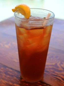 iced tea with a lemon in a clear plastic cup