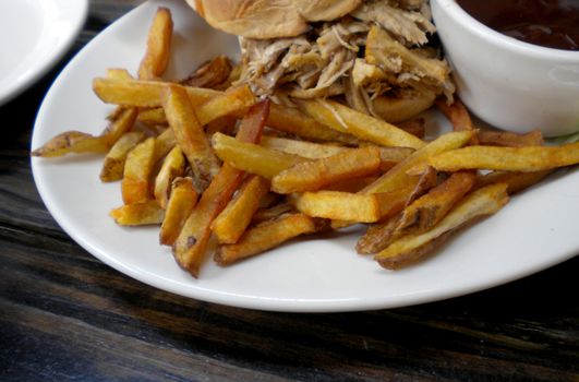 pulled pork sandwich and fries at restaurant