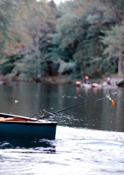 fishing in a canoe with a fishing pole in autumn in Maine