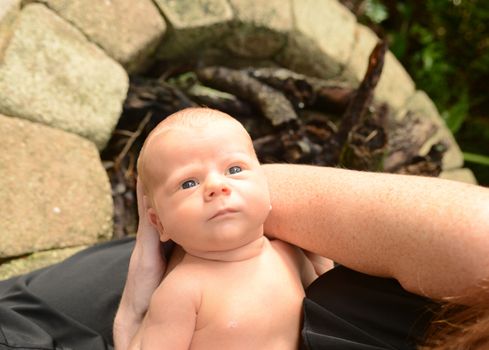 mom holding newborn infant outside