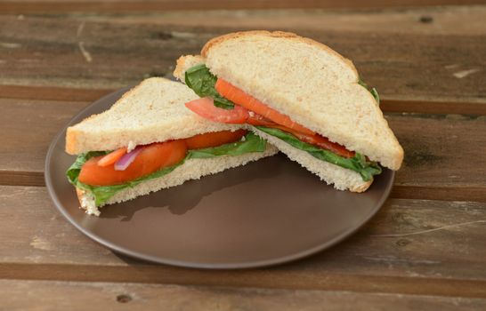 vegan sandwich on wheat bread with tomatoes and lettuce