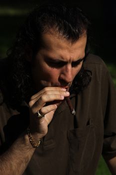 Close up of a person smoking a cigar.