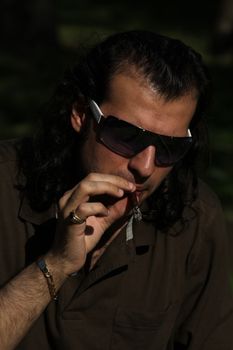 Close up of a person smoking a cigar.