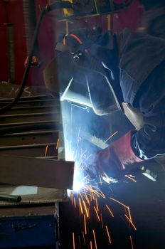 Welder with protective mask welding metal and sparks