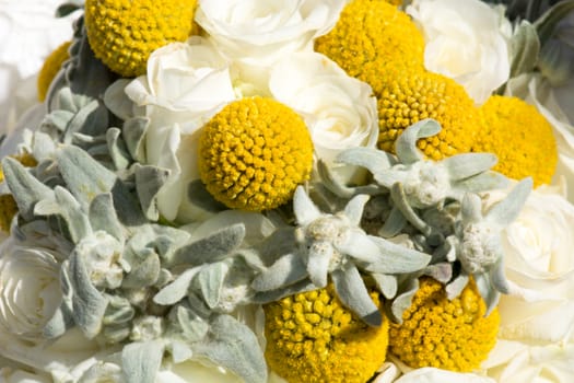 Detail of a bridal bouquet in summer with white roses and yellow flowers, warm mood