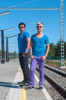 Two young trendy men standing on the platform
