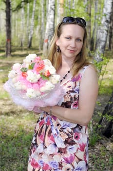 the happy woman with a bouquet from soft toys costs in the wood