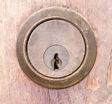 rounded aged keyhole on wooden wall - closed up