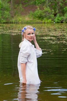 Beautiful woman in white shirt standing in pond
