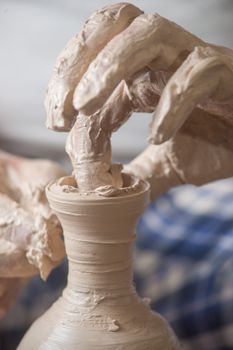 Hands of a potter, creating an earthen jar on the circle