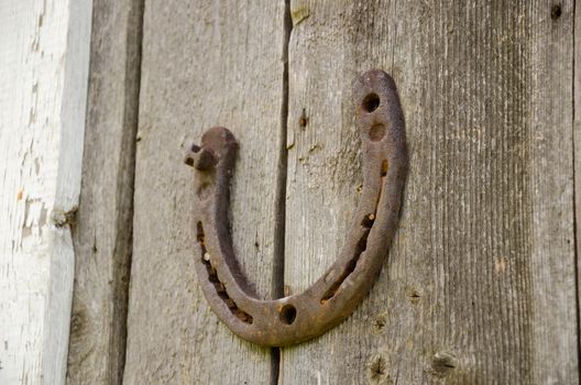 iron old rusty horseshoe symbol of happiness on wooden background