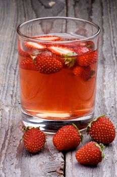 Homemade Strawberry Drink with Fresh Forest Strawberries in Glass on Wooden background