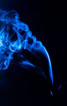 Flowing blue smoke on a black background. Isolated