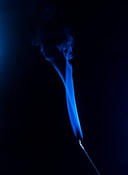 Flowing blue smoke on a black background. Isolated