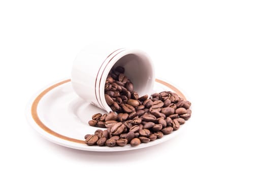 the roasted coffee beans in the cup on the white background
