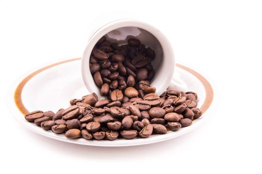 the roasted coffee beans in the cup on the white background