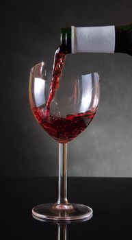 Pouring red vine into a broken glass