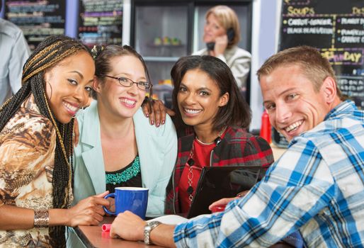 Diverse group of friends smiling in coffee house