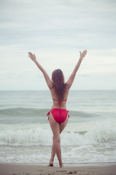 Sexy back of a beautiful asian woman in red bikini on sea background