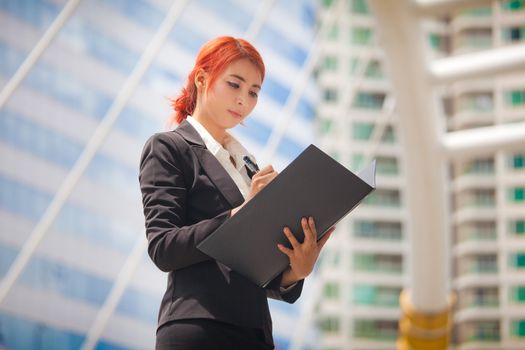 Young business asian woman with document at modern city