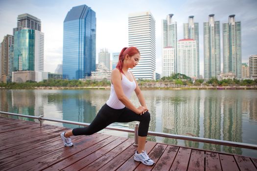 Beautiful young asian woman doing stretching exercise in the city