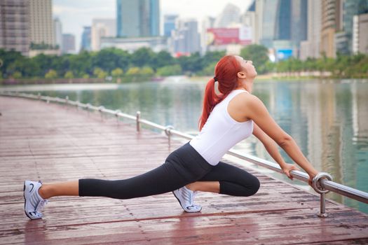 Beautiful young asian woman doing stretching exercise in the city