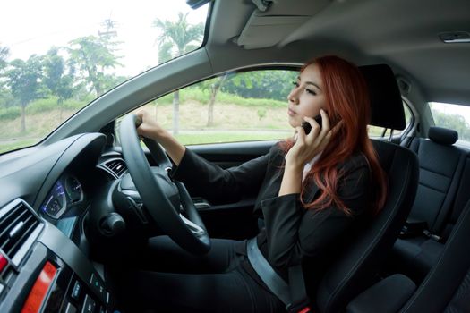 Beautiful young business asian woman using a smart phone in a car