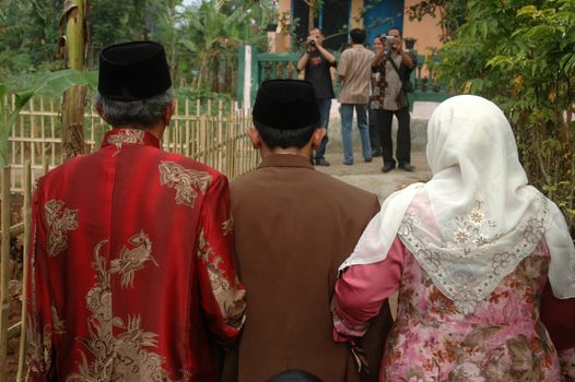 cikijing, west java, indonesia - july 10, 2011: groom and his big family are walking together into the bride house