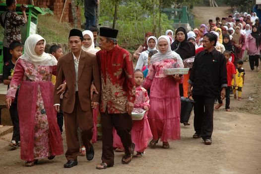 cikijing, west java, indonesia - july 10, 2011: groom and his big family are walking together into the bride house