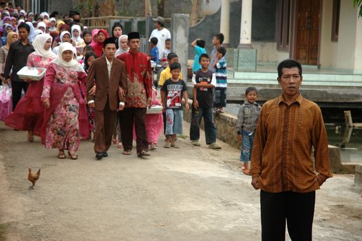 cikijing, west java, indonesia - july 10, 2011: groom and his big family are walking together into the bride house