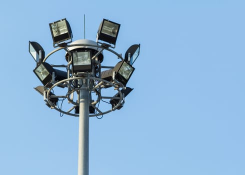 Tall spotlight tower against on blue sky